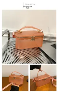 Detailed view of a transparent pink box bag featuring a wide logo shoulder strap