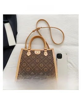 Gros plan détaillé du sac Boston rétro avec poignées en cuir marron et boucles dorées