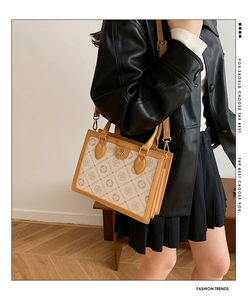 Detail showing vintage letter print tote with premium brown leather strap and stitching
