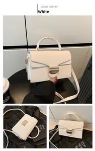 Detail of white lychee leather handbag with a metallic rectangular lock and a shoulder strap