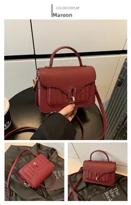 Détail du petit sac rouge jujube avec texture grain de litchi et boucle en métal doré