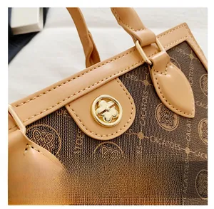 Detailed close-up of a vintage brown monogram fabric bag with a golden flower clasp