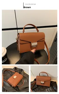 Close-up of brown litchi pattern leather bag with polished metal clasp and strap