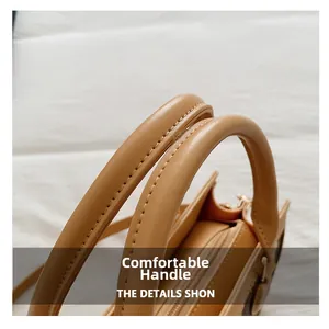 Close-up of comfortable reinforced handles and stitching on light brown faux leather bag