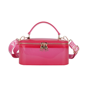 Pink translucent jelly box bag with dual zippers and wide lettered crossbody strap