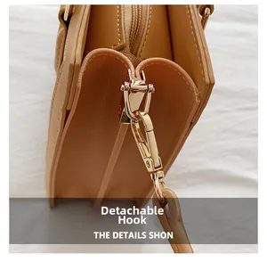 Detail of light gold detachable hook hardware on light brown synthetic leather bag
