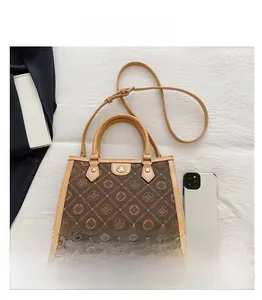 Top view of large capacity monogram tote bag with brown leather straps and metal lock