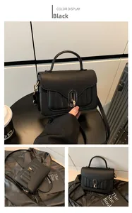 Vue détaillée du sac à main noir en cuir grainé avec fermoir métallique ovale et poignée