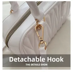 Détail du sac polochon blanc matelassé avec des crochets métalliques dorés amovibles