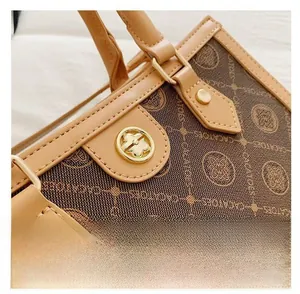 Close-up of brown monogram tote bag with leather trim and gold hardware detailing
