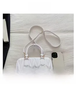 Vue détaillée du sac matelassé blanc avec poignée semi-circulaire et détails dorés