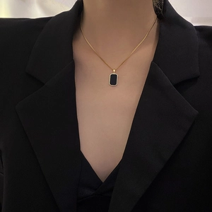 Nahaufnahme der minimalistischen schwarzen Rechteck-Halskette mit goldener Kette