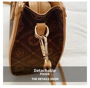 Macro detail of gold metal clasp and monogram fabric on a luxury crossbody tote bag