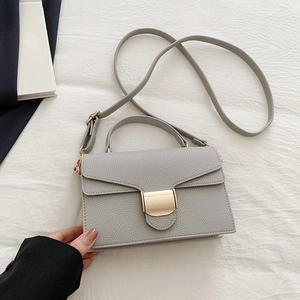 Minimalist light gray crossbody bag with pebble leather and golden metal clasp
