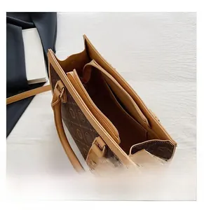 Detail view showing multi-layer interior compartments of a brown monogram tote bag