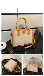 Detail view of cream vintage crossbody bag with letter print and gold logo hardware