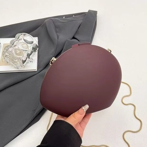 Elegant burgundy semi-circle clutch bag with gold chain strap and polished metal clasp