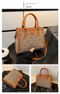 Brown tote bag with CACATOES monogram pattern, dual handles and golden hardware details