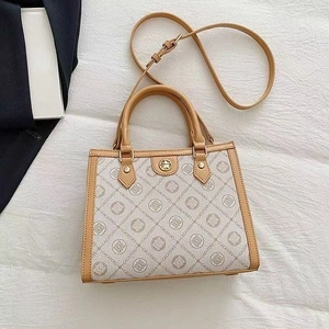 Beige and brown tote bag with logo pattern, dual top handles and adjustable shoulder strap