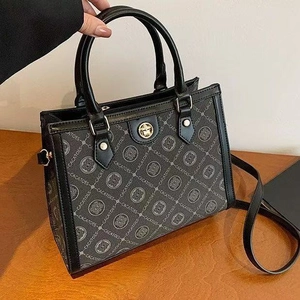Elegant monogram shoulder bag with leather trim and gold buckle, stylish tote for women