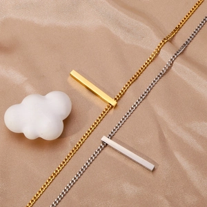 Détail des colliers barres polis or et argent sur un tissu élégant en soie champagne