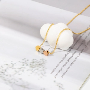 Collier minimaliste en acier titane avec pendentifs cœurs en or, argent et or rose