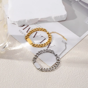 Grof goud en zilver Cubaanse ketting armbanden met graveerplaat op marmeren achtergrond