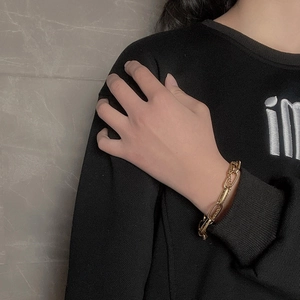Bracelet double couche en acier titane doré avec chaîne trombone sur modèle féminin