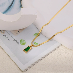Détail de la chaîne serpent dorée avec pendentif en zircon émeraude rectangulaire
