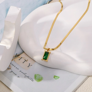 Détail du collier à chaîne serpent dorée avec pendentif rectangulaire en zircon vert