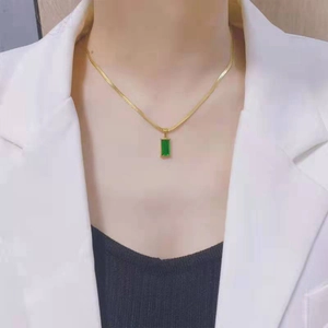 Collier chaîne serpent dorée avec pendentif zircon vert rectangulaire sur un modèle