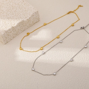 Detail van titanium hartvormige hanger kettingen in goud en zilver met een karabijnsluiting