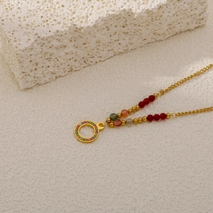 Detailansicht der Gold-Titan-Halskette mit buntem Zirkonring und Perlenketten-Akzent