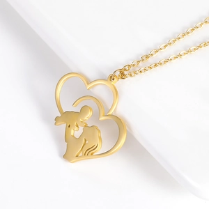 Macro del ciondolo a cuore dorato con design della silhouette madre e bambino