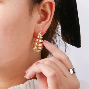 Minimalistische goldene Spiralkegel-Ohrringe mit Glanzeffekt am Modell für Damen