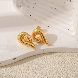 Detailaufnahme eleganter vergoldeter unregelmäßiger geometrischer Ohrstecker auf Tablett