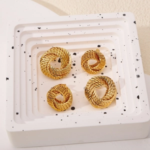 Détail de créoles torsadées dorées en deux tailles avec texture de métal tressé
