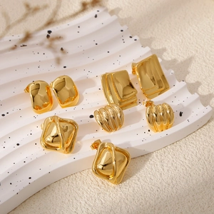 Elegantes Set goldener geometrischer Ohrringe in Rechteckform auf Keramikschale