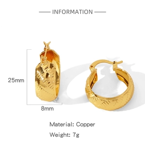 Detail showing 25mm gold geometric hoop earrings with textured cross pattern and copper finish