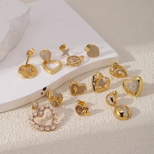 Detailed view of assorted gold-plated earrings with hearts and star-planet crystal charms