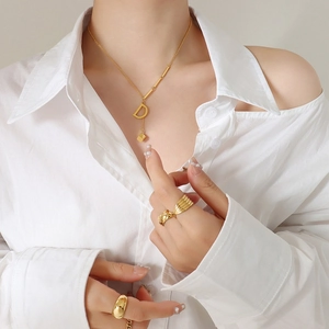 Classic gold letter D pendant necklace and mixed style ring set worn on model