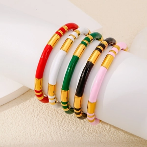 Detail showing five colorful enamel bamboo style bracelets with shiny gold plated accents