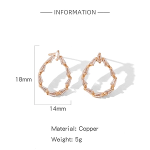 Détail de boucles d'oreilles gouttes dorées en cuivre avec zircons baguette 18x14 mm