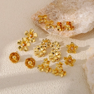 Exquisite golden flower stud earrings set with sparkling zircons on natural stone background