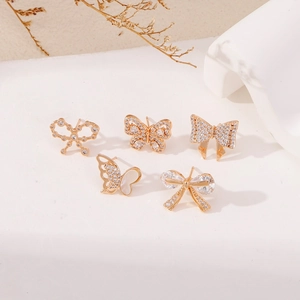 Ensemble de boucles d'oreilles dorées papillon et nœud avec zircons brillants