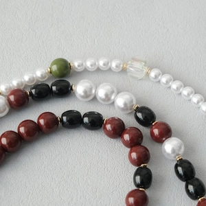 Macro shot of stylish acrylic beads and pearls with gold metal spacers on a textured surface