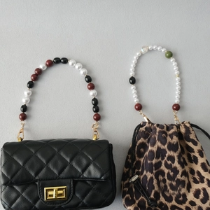 Detail of luxury pearl and acrylic bead handles on quilted flap and leopard bucket bags