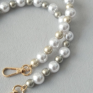 Détail de la sangle en perles de luxe avec perles blanches et champagne et fermoir doré