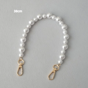 Détail d'une bandoulière de 38cm en perles crème avec fermoirs mousquetons dorés polis