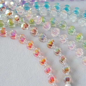 Close-up of colorful iridescent pumpkin acrylic beads on a stylish handbag strap